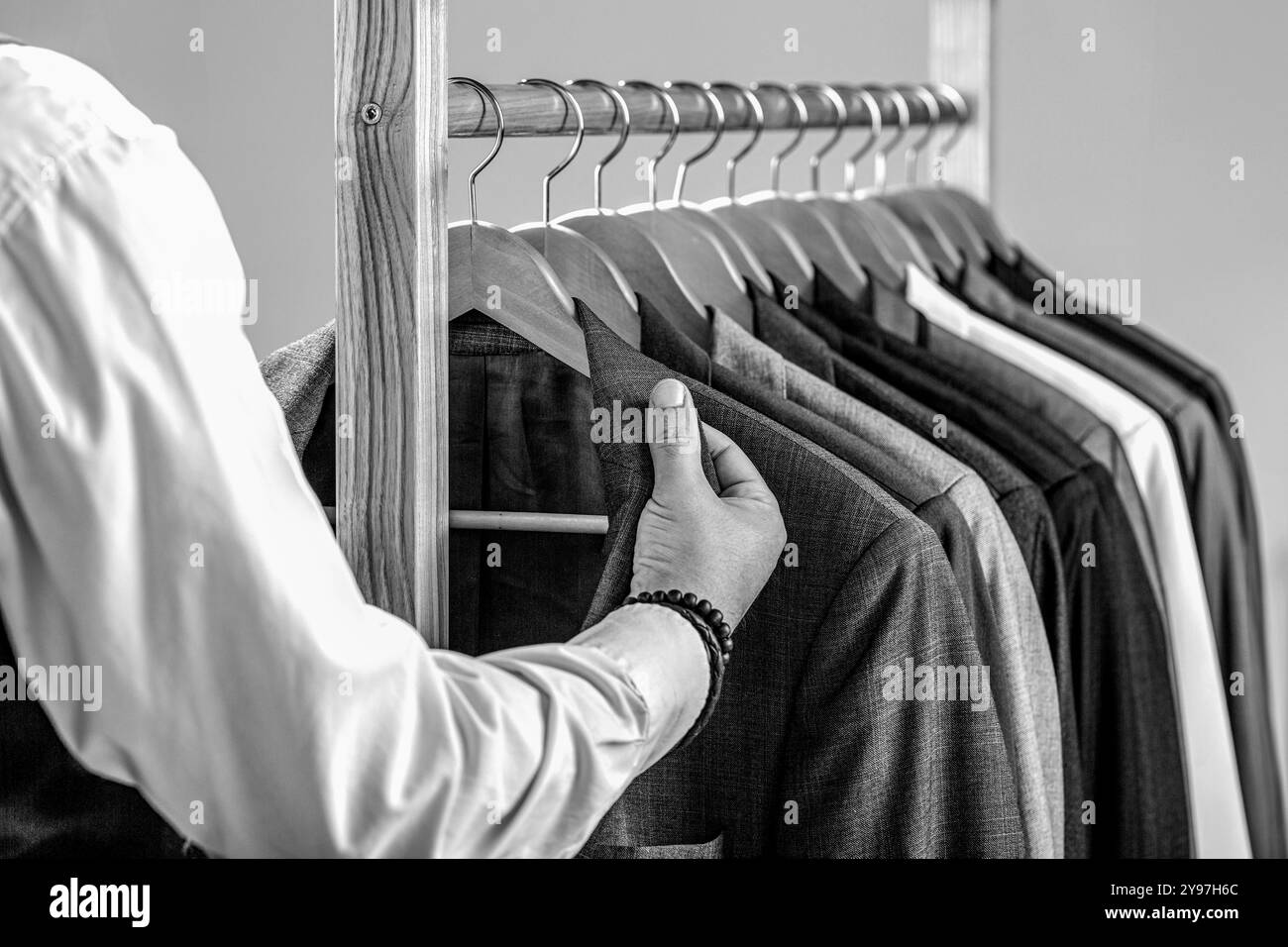 Männeranzug, Schneiderin in seiner Werkstatt. Modemann im klassischen Kostümanzug. Schwarz-weiß Stockfoto