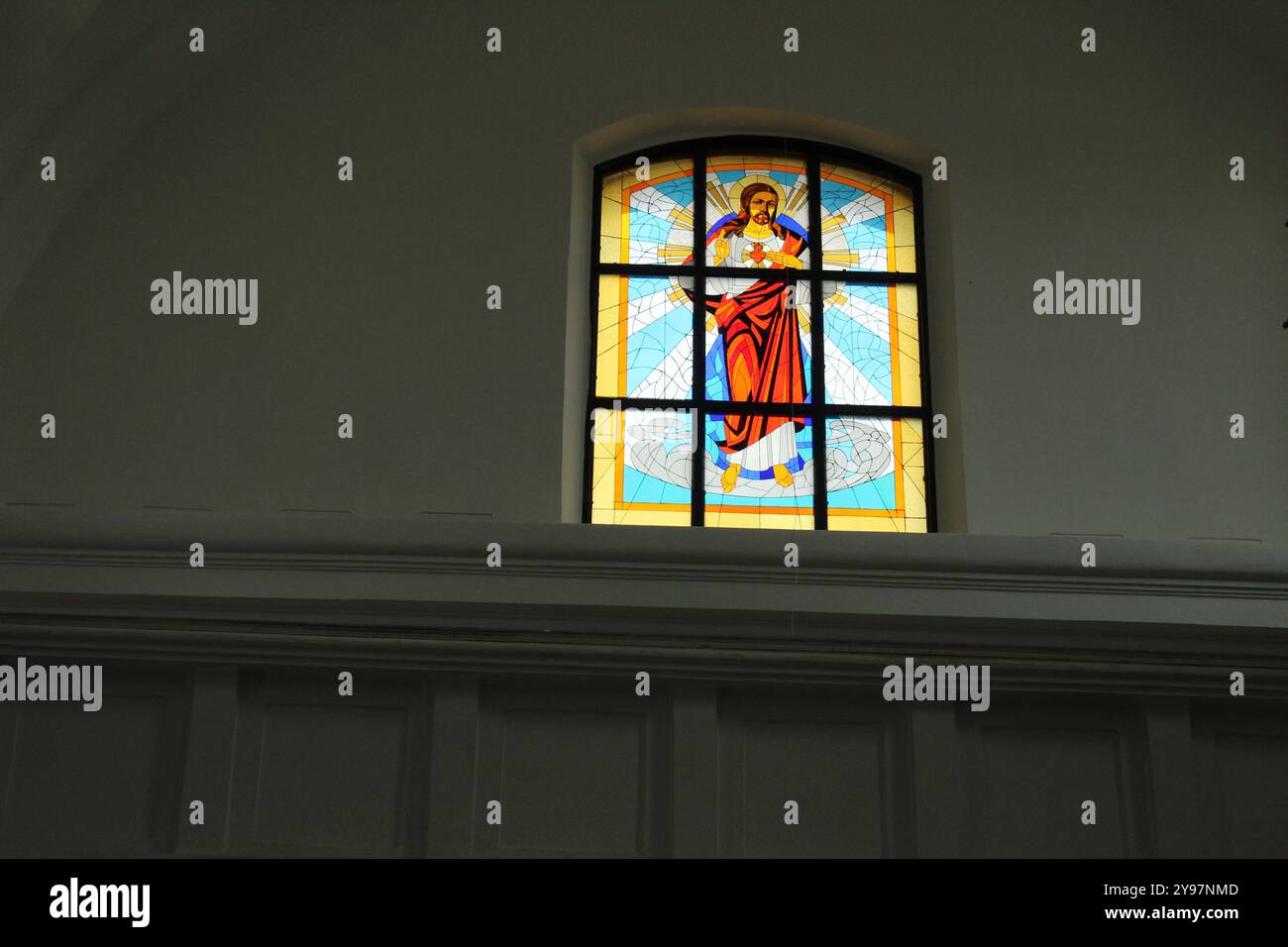 Buntglas auf dem Fenster auf grauem Hintergrund mit Platz für Text im Copyspace. Buntglasfenster in der Kirche, im Tempel, in der katholischen Kirche. Stockfoto
