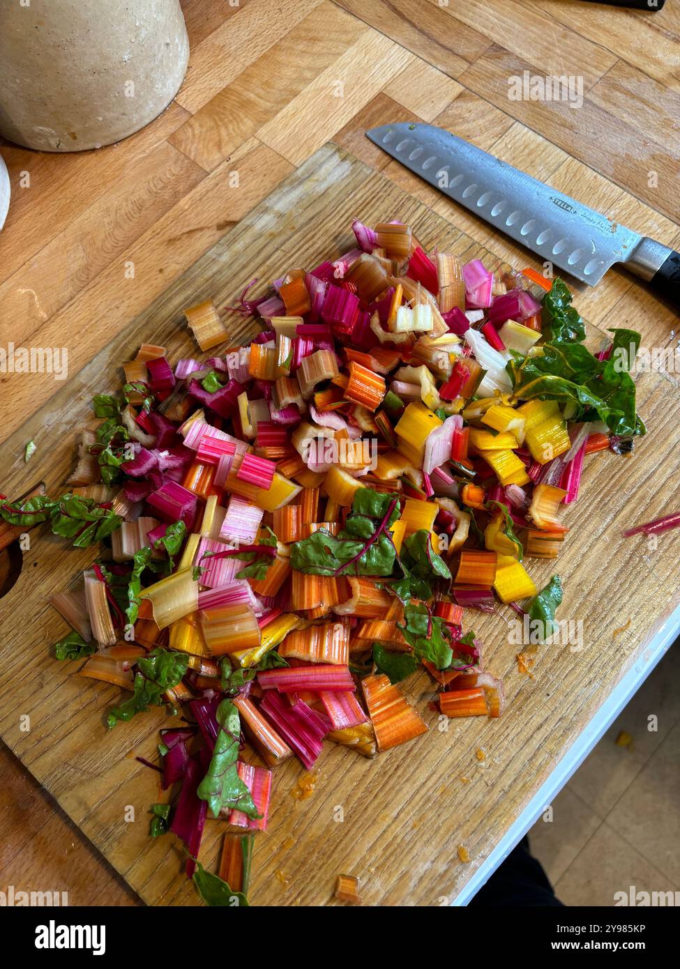 Gehackte Mangold-Stiele auf Schneidebrett - Smartphone-aufgenommenes Stockfoto
