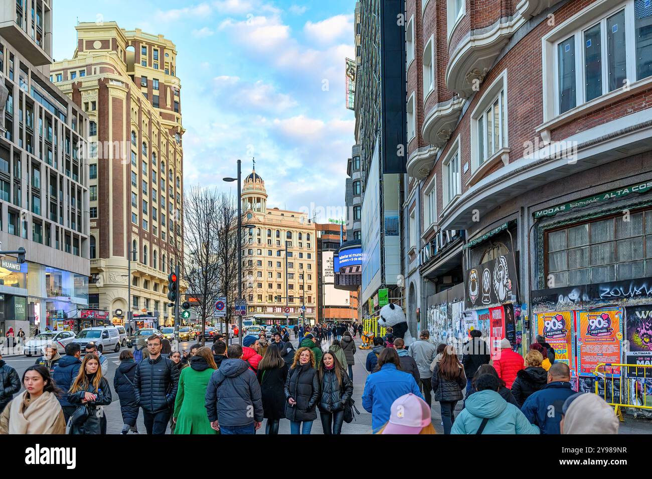 Eine große Gruppe von Leuten spaziert entlang der Gran Via, einem berühmten Ort in der Stadt. Stockfoto