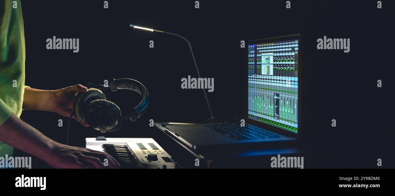 Ein Musiker kreiert Musik in seinem Studio. Ein Pianist nimmt zu Hause Musik auf. Stockfoto