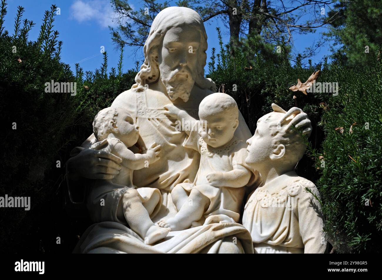 Detail einer Skulptur von Jesus umgeben von Kindern an einem Grab auf dem historischen Lexington Cemetery in Lexington, Kentucky. Stockfoto