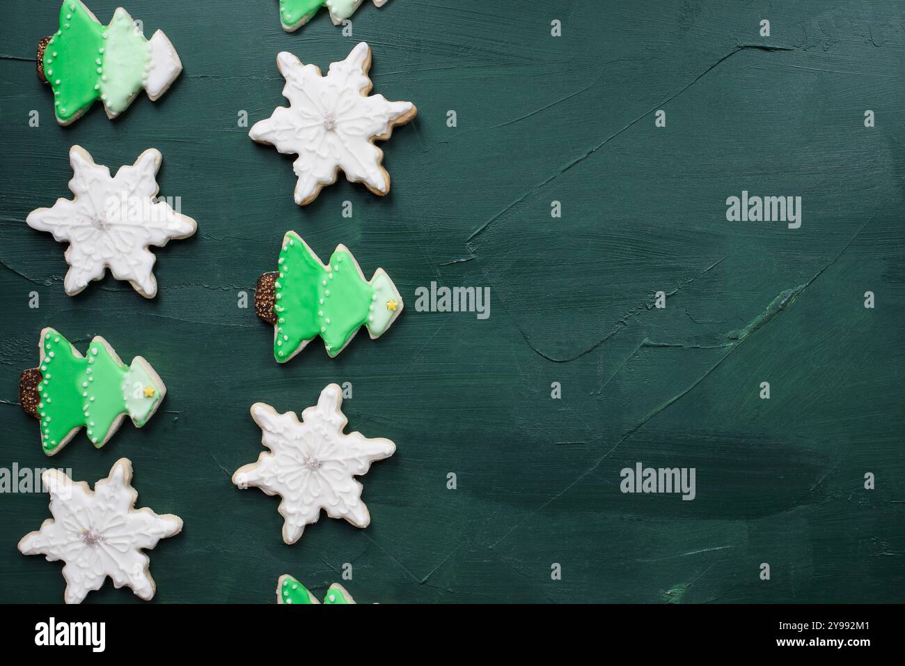 Frostiger Weihnachtsbaum und sternförmige Kekse oder Kekse mit Ombre-Grün-weiß-Glasur auf rustikalem Hintergrund. Draufsicht von oben. Stockfoto