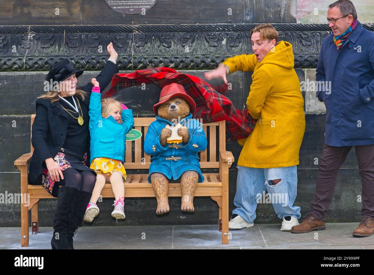 Edinburgh, Schottland. Mittwoch, 9. Oktober 2024. Links zum Stellvertretenden Lord Provost, Councillor Lezley Marion Cameron, Lyra, Councillor Finlay McFarlane (gelber Mantel) und CEO von Essential Edinburgh Roddy Smith mit Paddington bei der Enthüllung der Bärenstatue in Edinburgh, die auch in Städten, Städten und Schönheitsstätten in ganz Großbritannien und Irland kommen, vor dem jüngsten Kinobesuch von bearÕs, PADDINGTON in PERU, in Großbritannien und Irland, am 8. November. Brian D Anderson Stockfoto