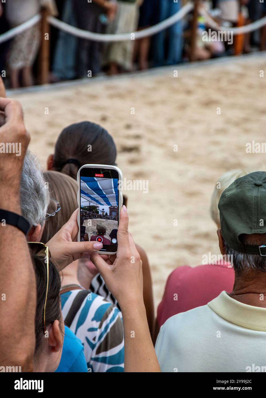 09/20/2024. Fuengirola, Malaga, Spanien. Zuschauer nehmen mit dem Mobiltelefon die Leistung der Reiter während der Feier des Pferdetages auf Stockfoto