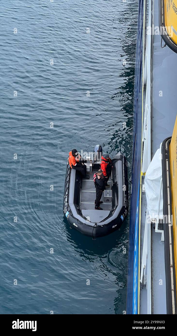 Besatzungsmitglieder an Bord eines kleinen Expeditionsbootes bereiten sich auf eine Landung in den Gewässern der Antarktis vor, neben der Lindblad Nat Geo Endurance Stockfoto