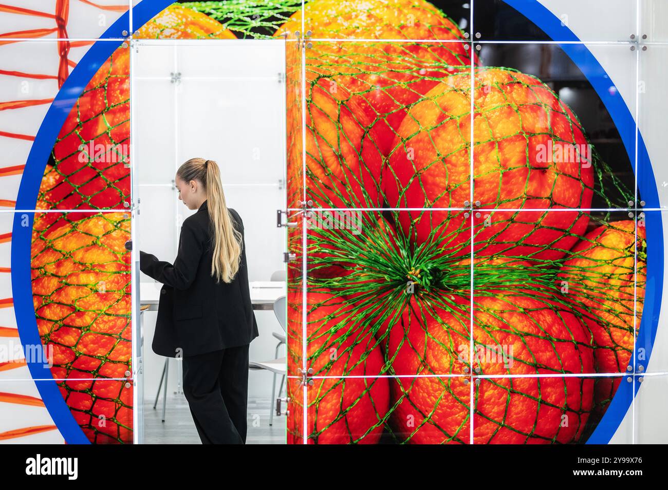 Madrid, Spanien. Oktober 2024. Eine Frau an einem Orangenstand auf der Frucht-Attraktion 2024 in der IFEMA. Fruit Attraction ist eine der wichtigsten europäischen Messen in der Agrar- und Lebensmittelindustrie. Quelle: Marcos del Mazo/Alamy Live News Stockfoto