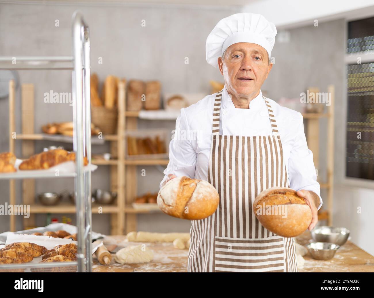 Erfolgreicher Senior Bäcker mit frisch gebackenem Brot Stockfoto