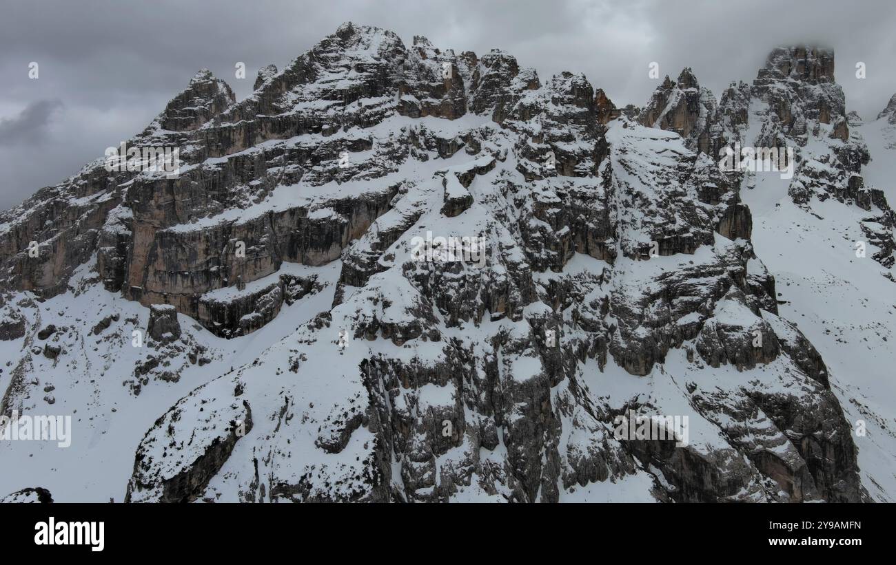 Aus der Vogelperspektive auf atemberaubende felsige Berge im Schnee unter stimmungsvollen grauen Wolken, Dolomiten, Italien, Europa Stockfoto