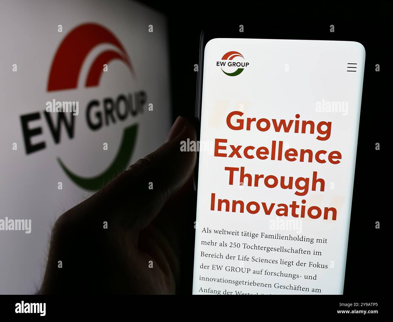 Deutschland. August 2024. In dieser Fotoabbildung hält eine Hand ein Smartphone mit dem Logo des deutschen Viehzuchtunternehmens EW Group GmbH vor der Website. Quelle: SOPA Images Limited/Alamy Live News Stockfoto