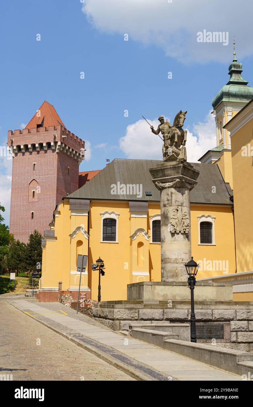 Posen, Polen - 18. Juni 2023: In den pulsierenden Straßen von Posen, Polen, steht ein beeindruckendes gelbes Gebäude neben einer historischen Statue und einem Turm, Showca Stockfoto