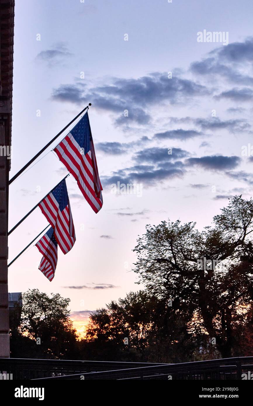 Drei amerikanische Flaggen sind vor einem sonnigen Himmel am frühen Morgen sichtbar Stockfoto