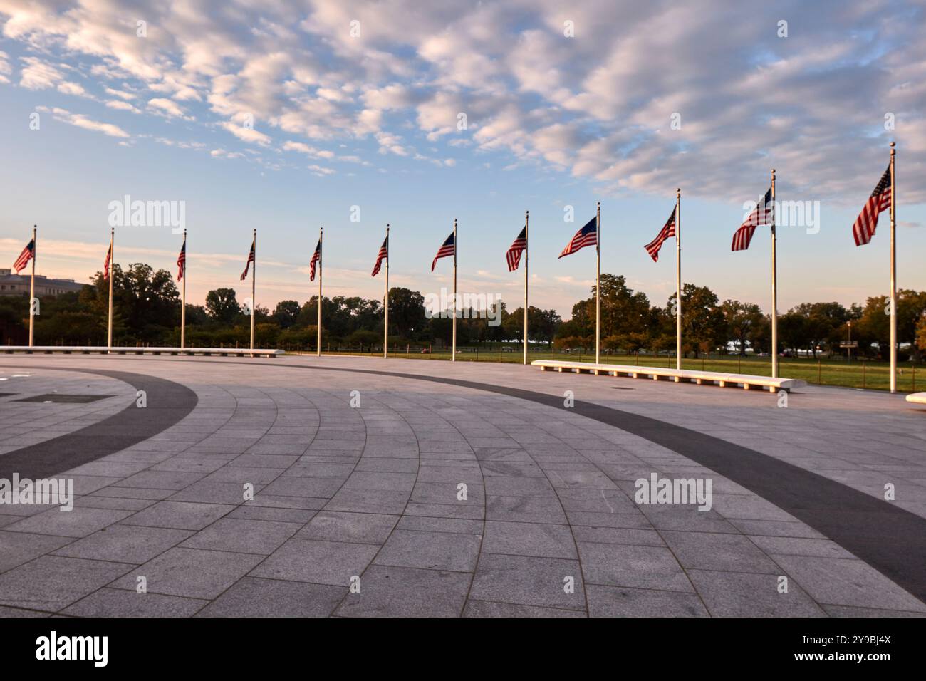 Ein ruhiger Blick auf eine Reihe amerikanischer Flaggen, die bei Sonnenuntergang sanft im Wind flattern. Stockfoto