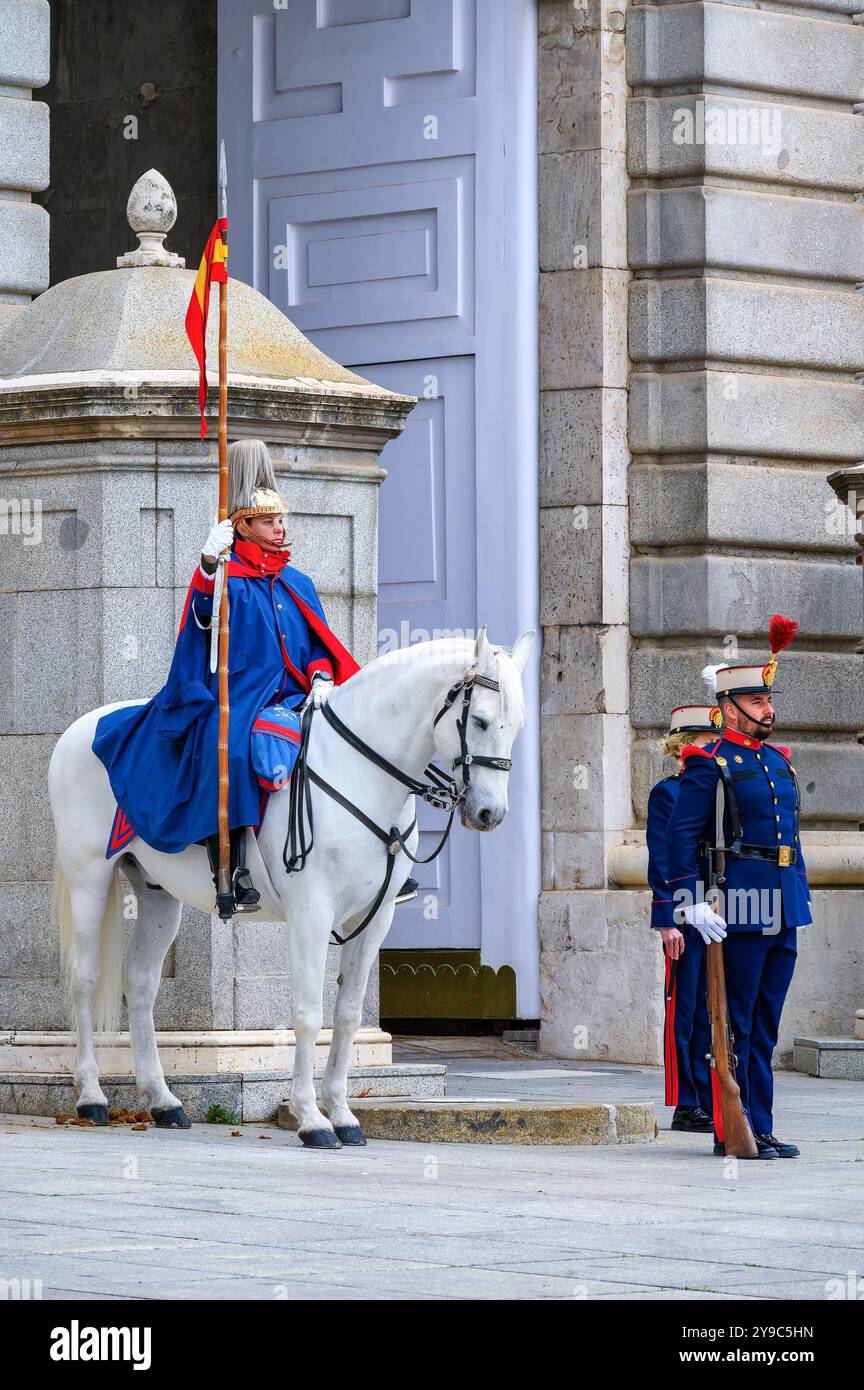 Madrid, Spanien - 5. Oktober 2024: Drei uniformierte Soldaten am Eingang des Königspalastes, die die Zeremonie des Wachwechsels durchführen. Stockfoto