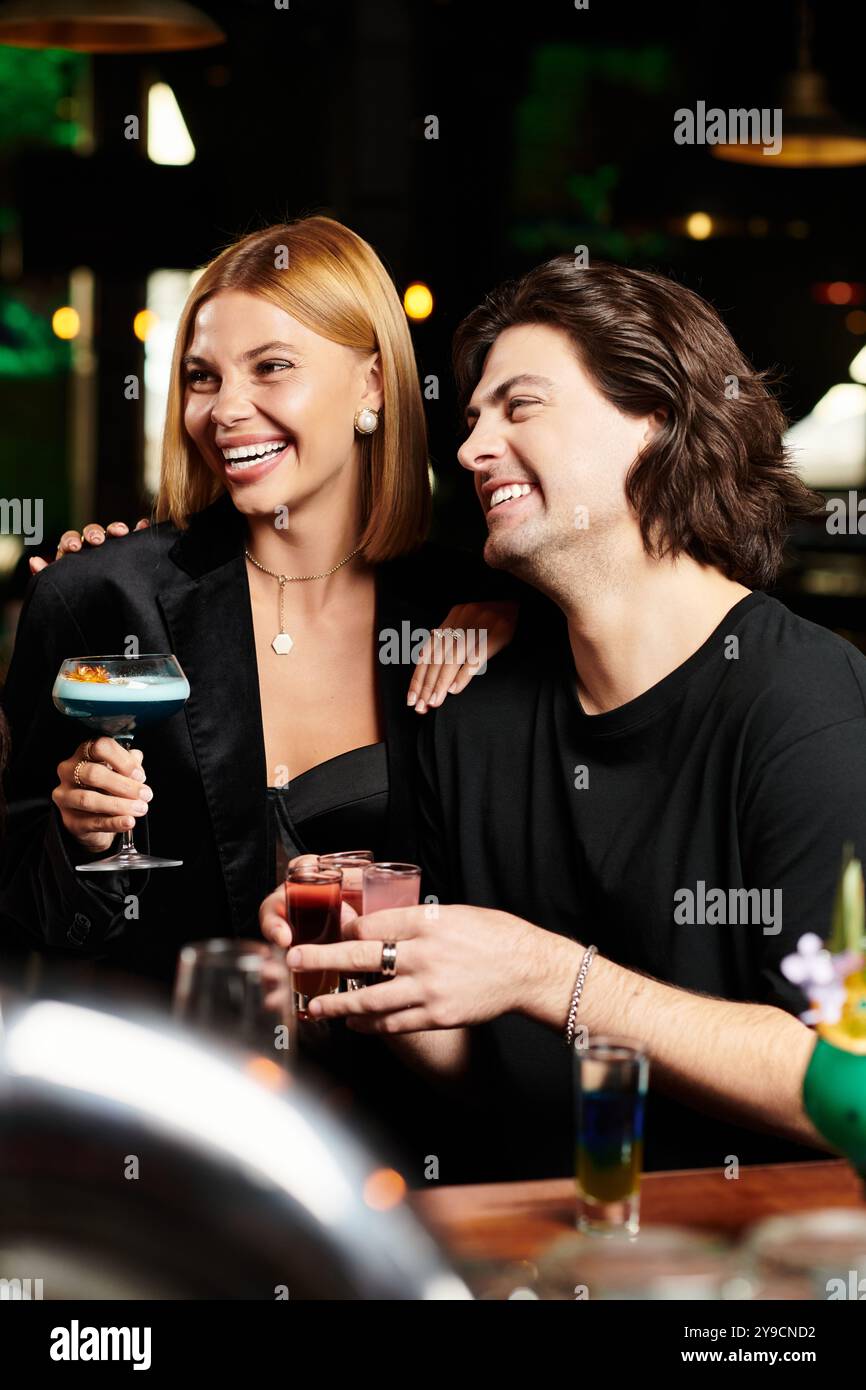 Kollegen genießen Drinks und Lachen, während sie auf einer festlichen Firmenfeier feiern. Stockfoto