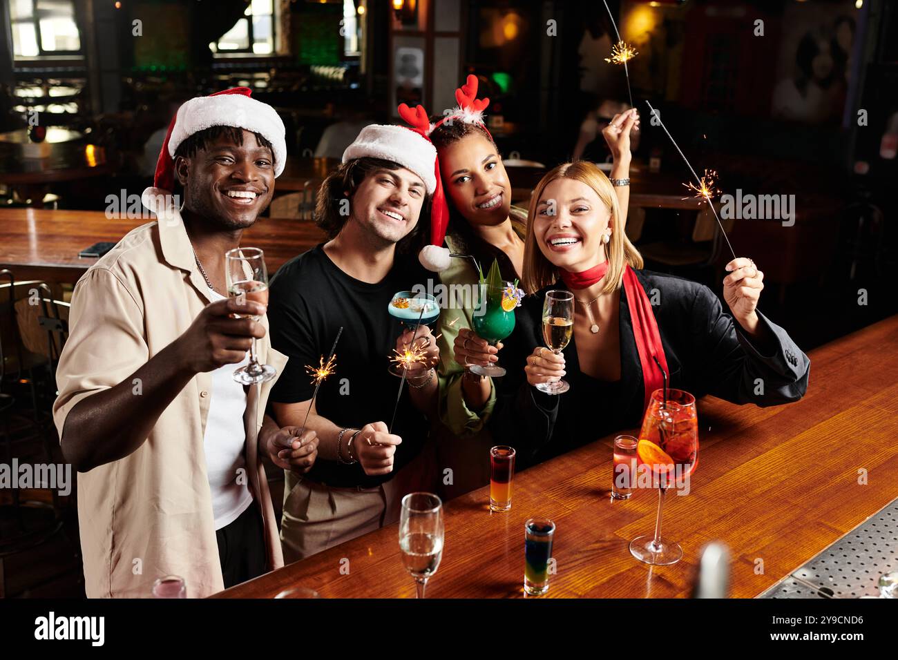 Kollegen treffen sich auf einer lebhaften Firmenfeier, genießen festliche Drinks und lachen gemeinsam. Stockfoto