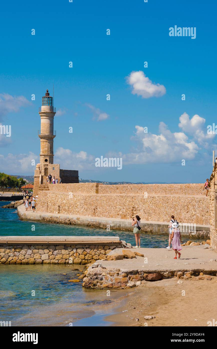 Mediterraner Urlaub, Rückansicht der jungen Frauen, die entlang der malerischen venezianischen Hafenmauer in Chania (Hania) Kreta, Griechenland Stockfoto