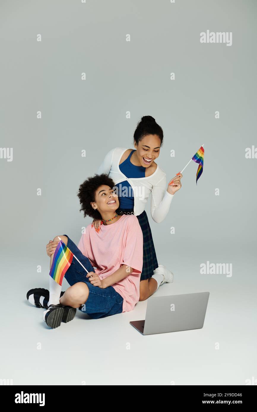 Eine lebhafte Feier der Freundschaft, während zwei Personen einen Moment der Freude mit Stolz-Flaggen teilen. Stockfoto
