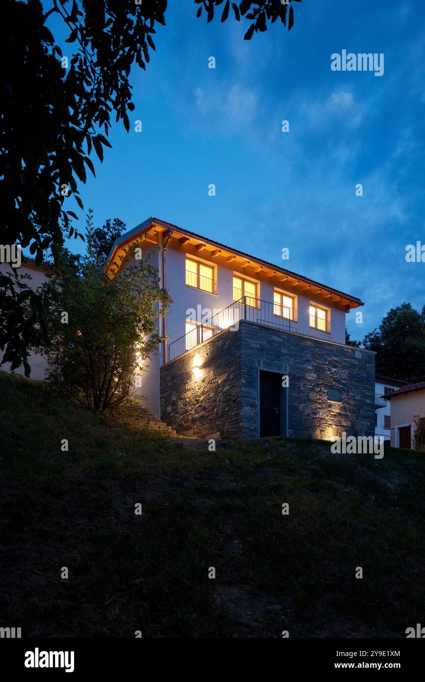 Freistehendes Haus, gerade renoviert, mit moderner Ausstattung. Rückseite des Hauses mit großem privaten grünen Garten. Nachtszene, niemand drinnen Stockfoto