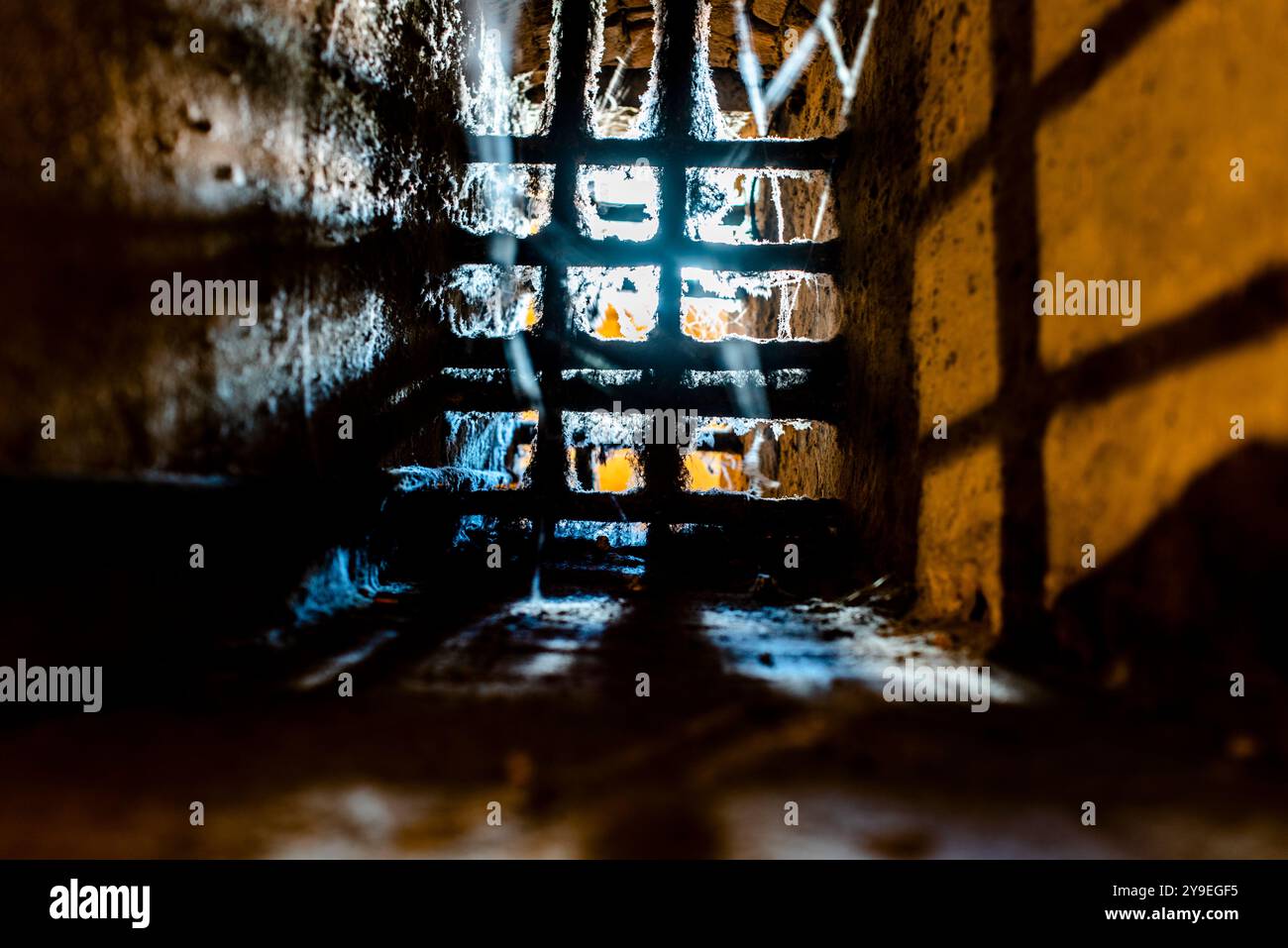 Altes Fenster mit Gittern und Spinnweben in den Kerkern der Burg Estensi in Ferrara, Italien Stockfoto