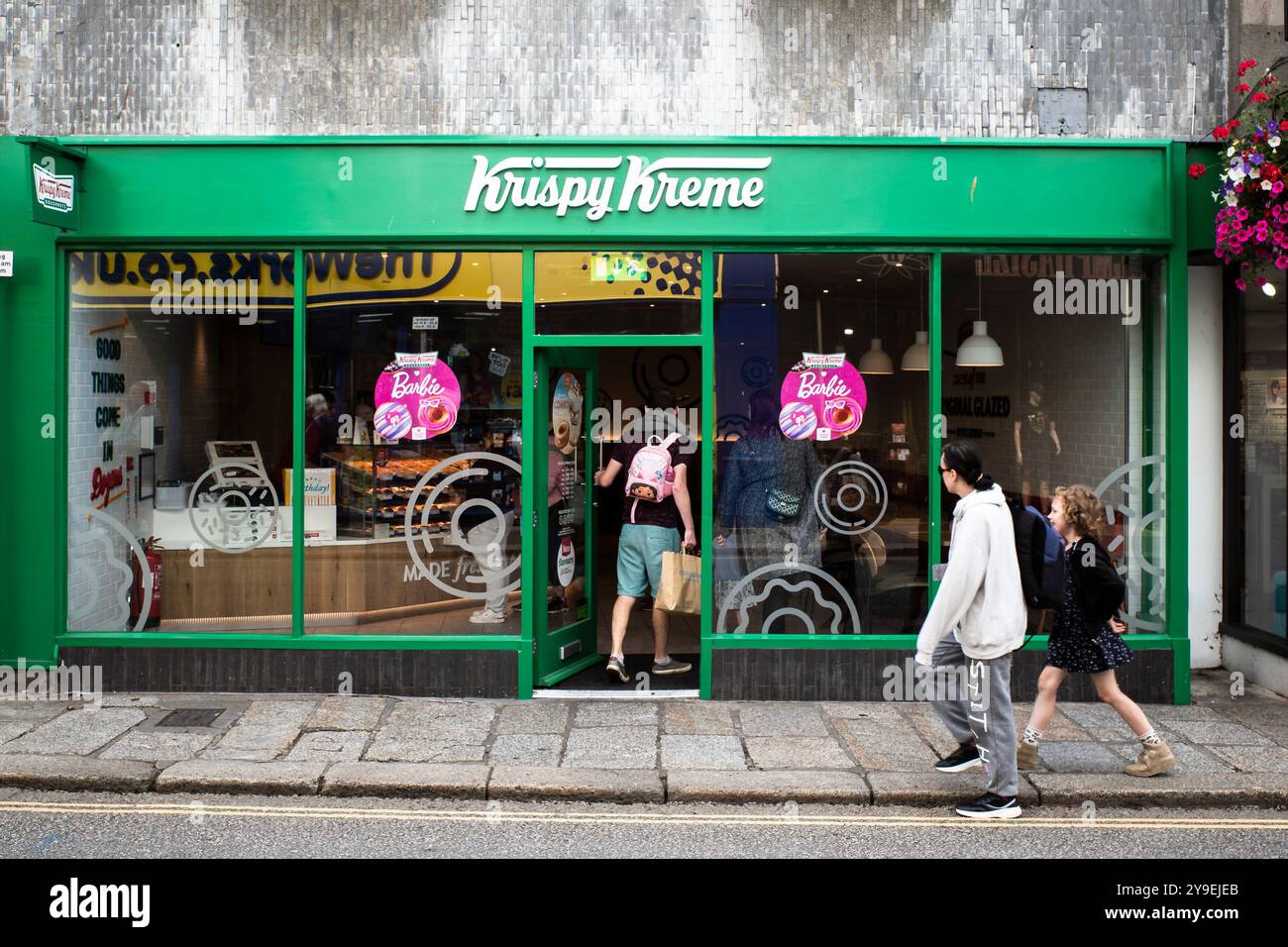 Kunden, die einen Donut-Shop von Krispy Kreme im Zentrum von Truro in Cornwall in Großbritannien betreten. Stockfoto