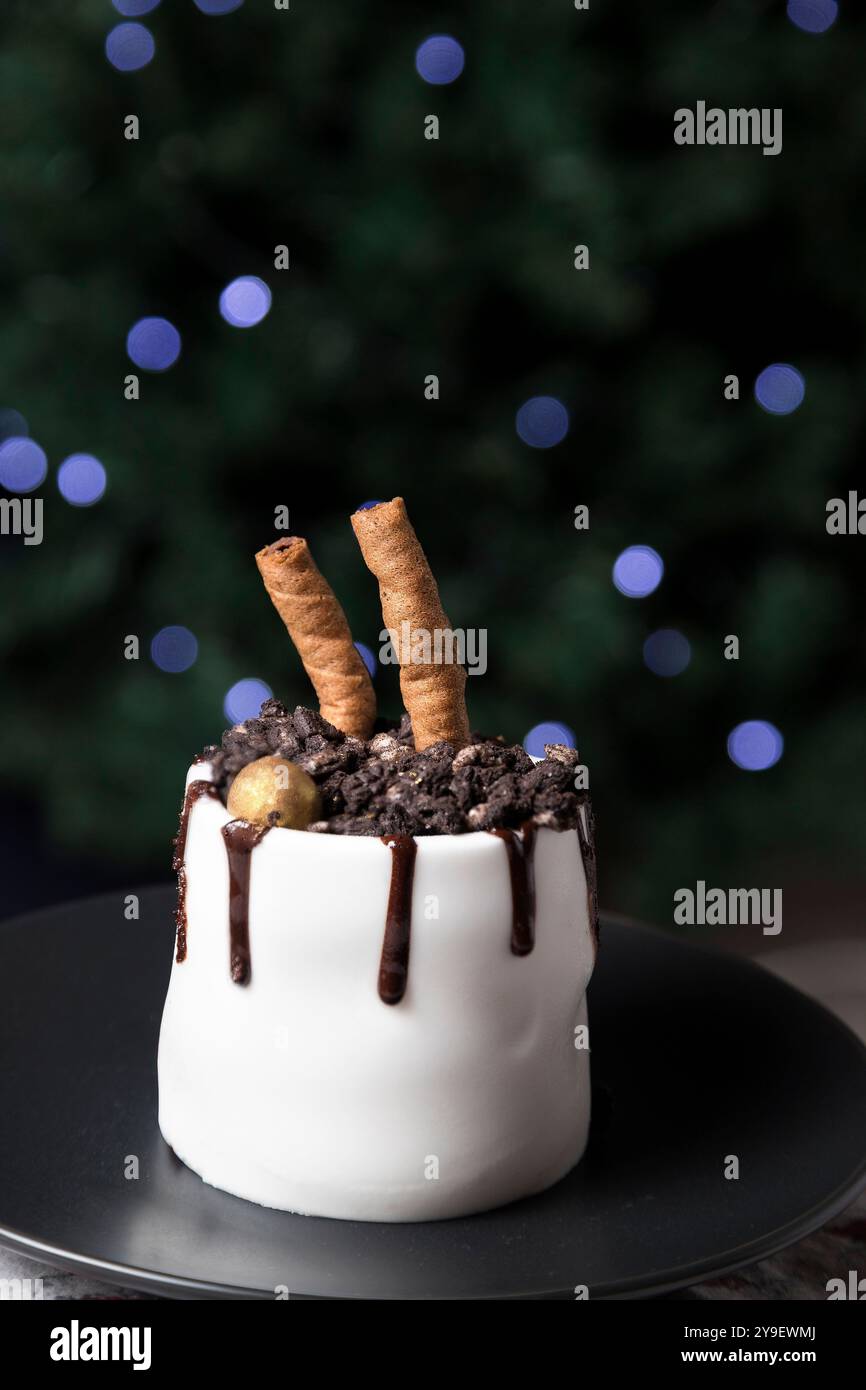 Wunderschöner Kuchen auf einem Teller neben der Weihnachtsbaumdekoration. Weihnachten Hintergrund Stockfoto