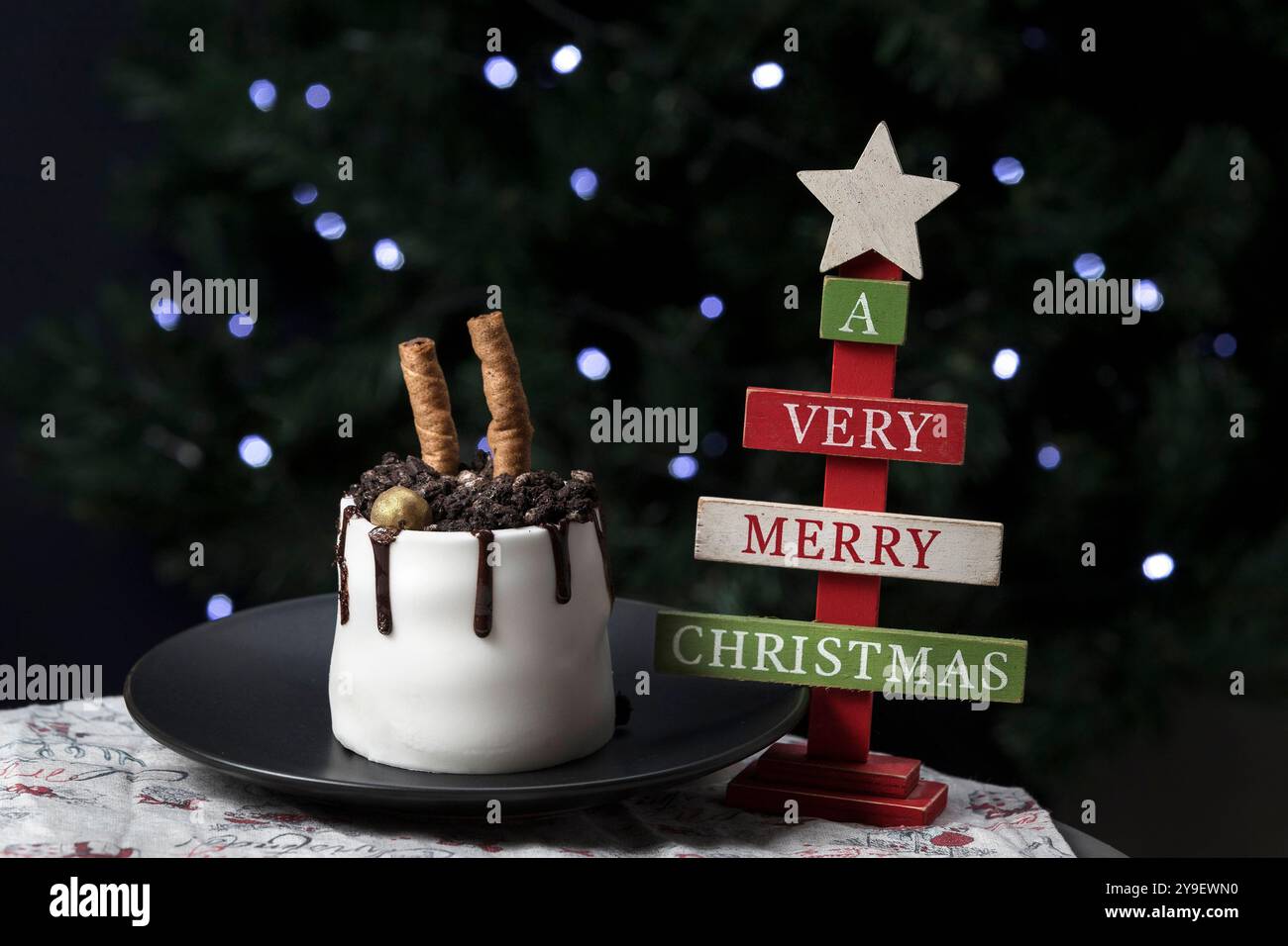 Wunderschöner Kuchen auf einem Teller neben der Weihnachtsbaumdekoration. Weihnachten Hintergrund Stockfoto