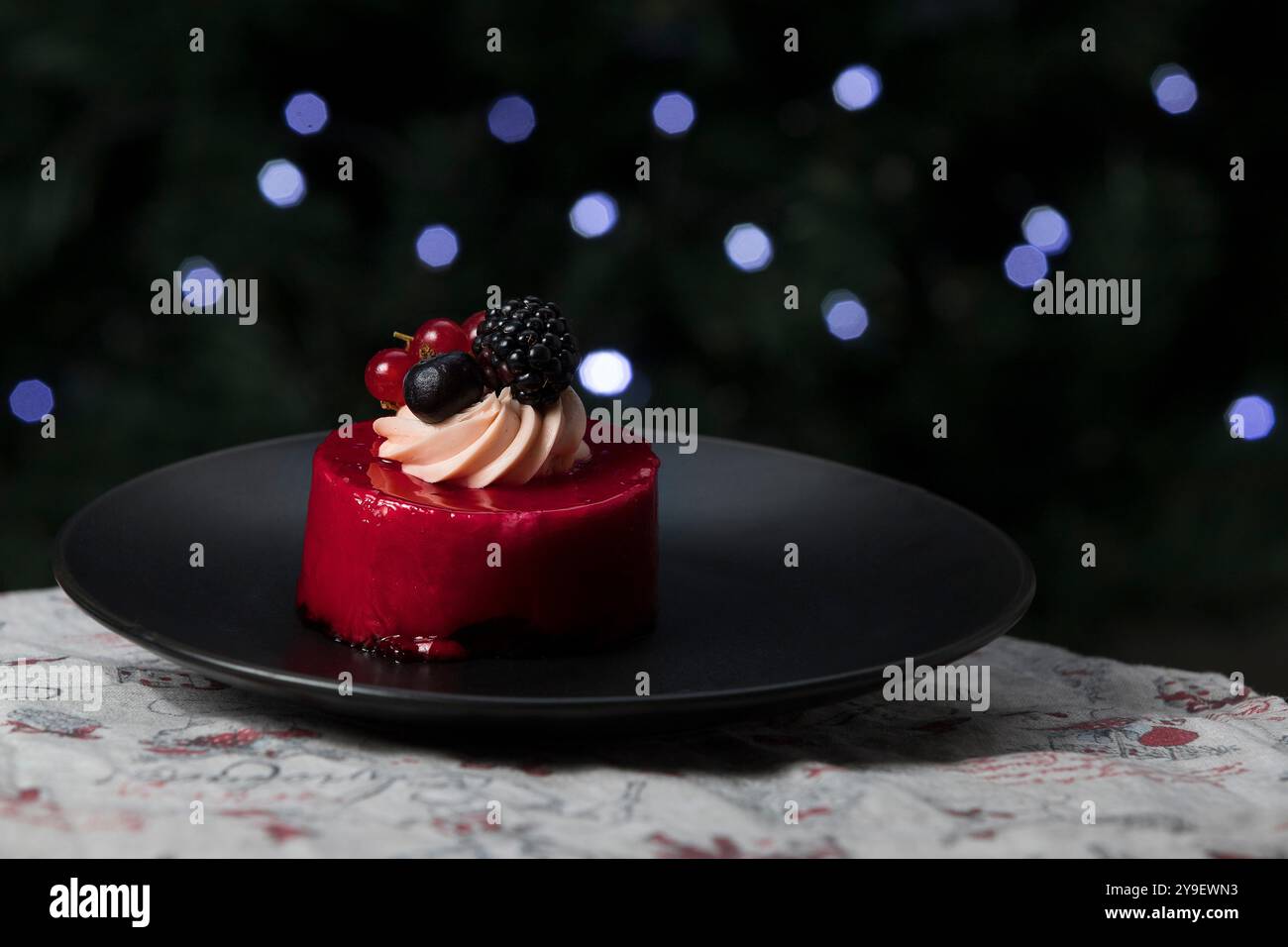 Wunderschöne Torte auf einem Teller, dekoriert mit Beeren. Weihnachten Hintergrund. Bokeh Weihnachten Stockfoto