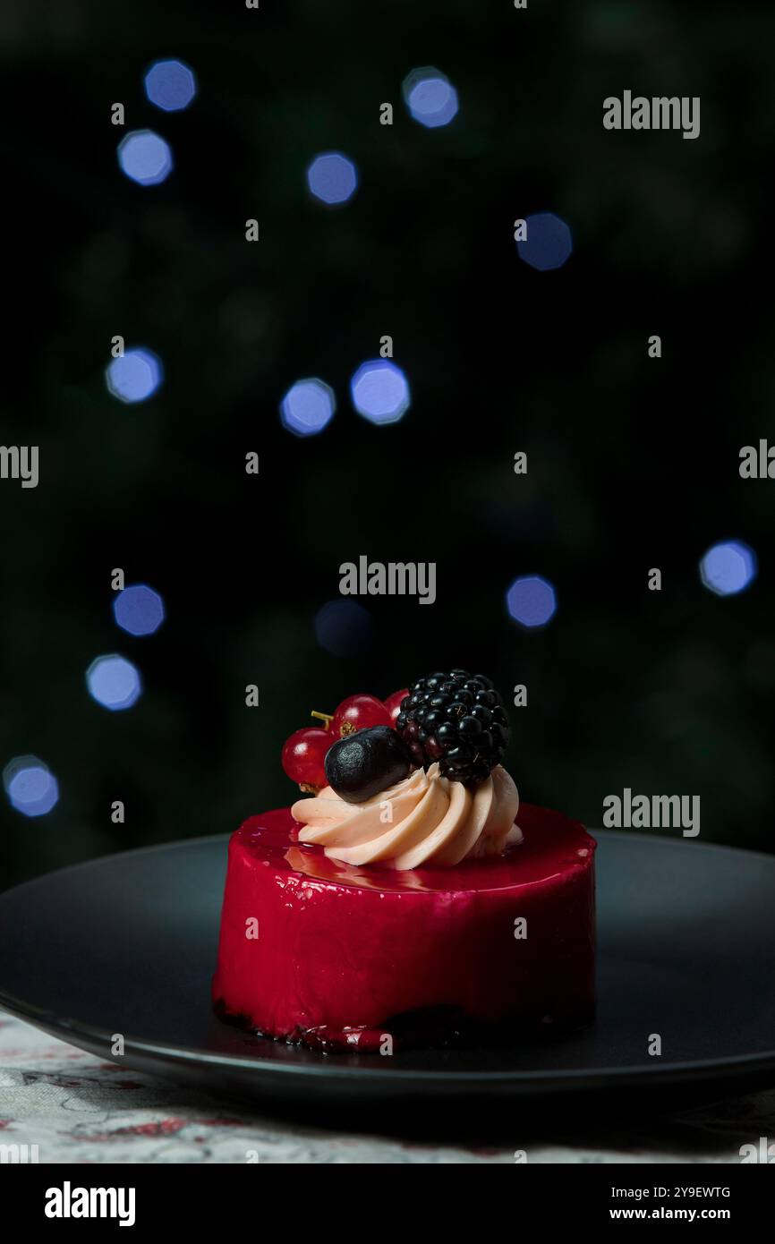 Wunderschöne Torte auf einem Teller, dekoriert mit Beeren. Weihnachten Hintergrund. Bokeh Weihnachten Stockfoto