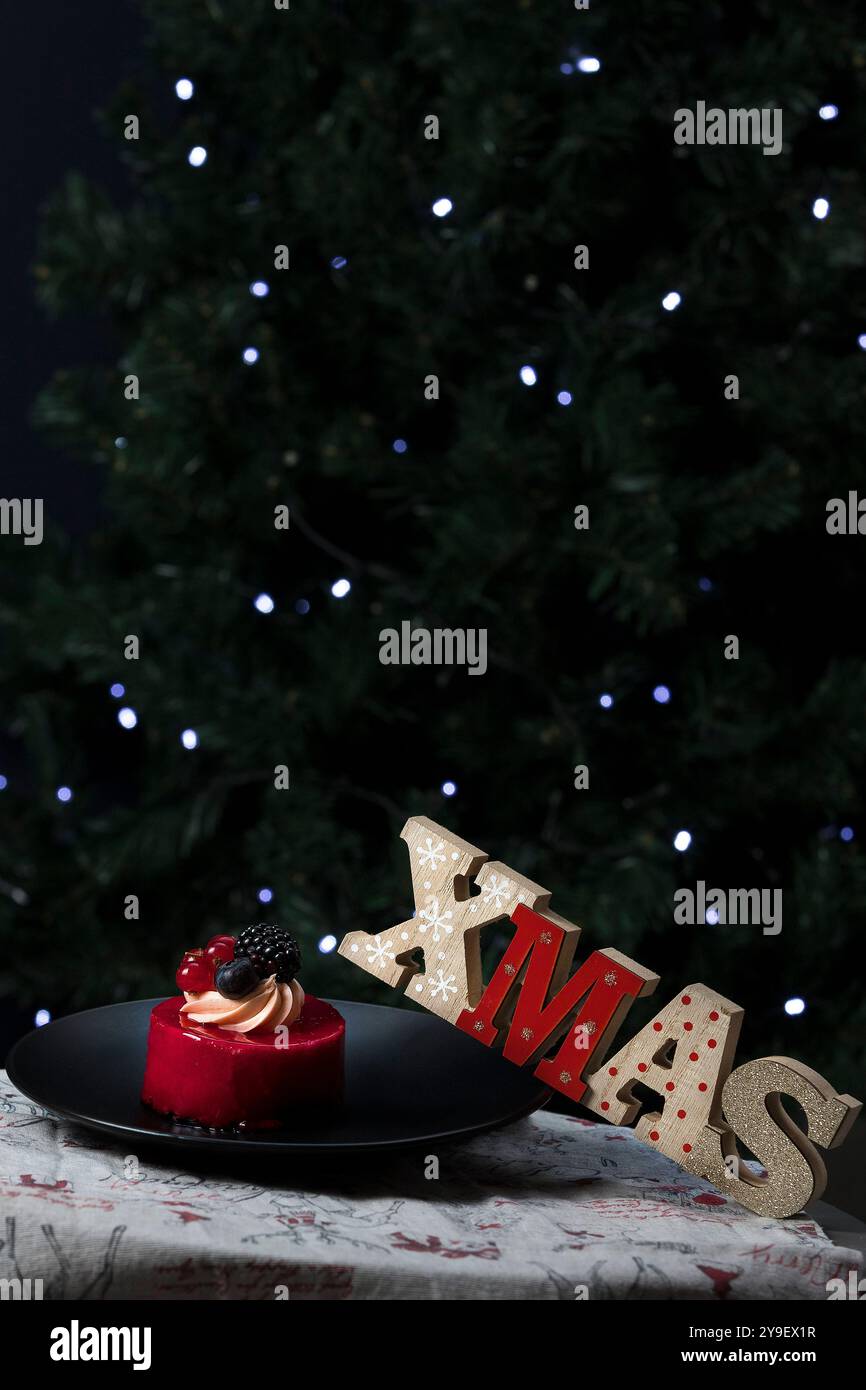 Wunderschöne Torte auf einem Teller neben Weihnachtsdekoration. Weihnachten Hintergrund. Bokeh weihnachten Stockfoto