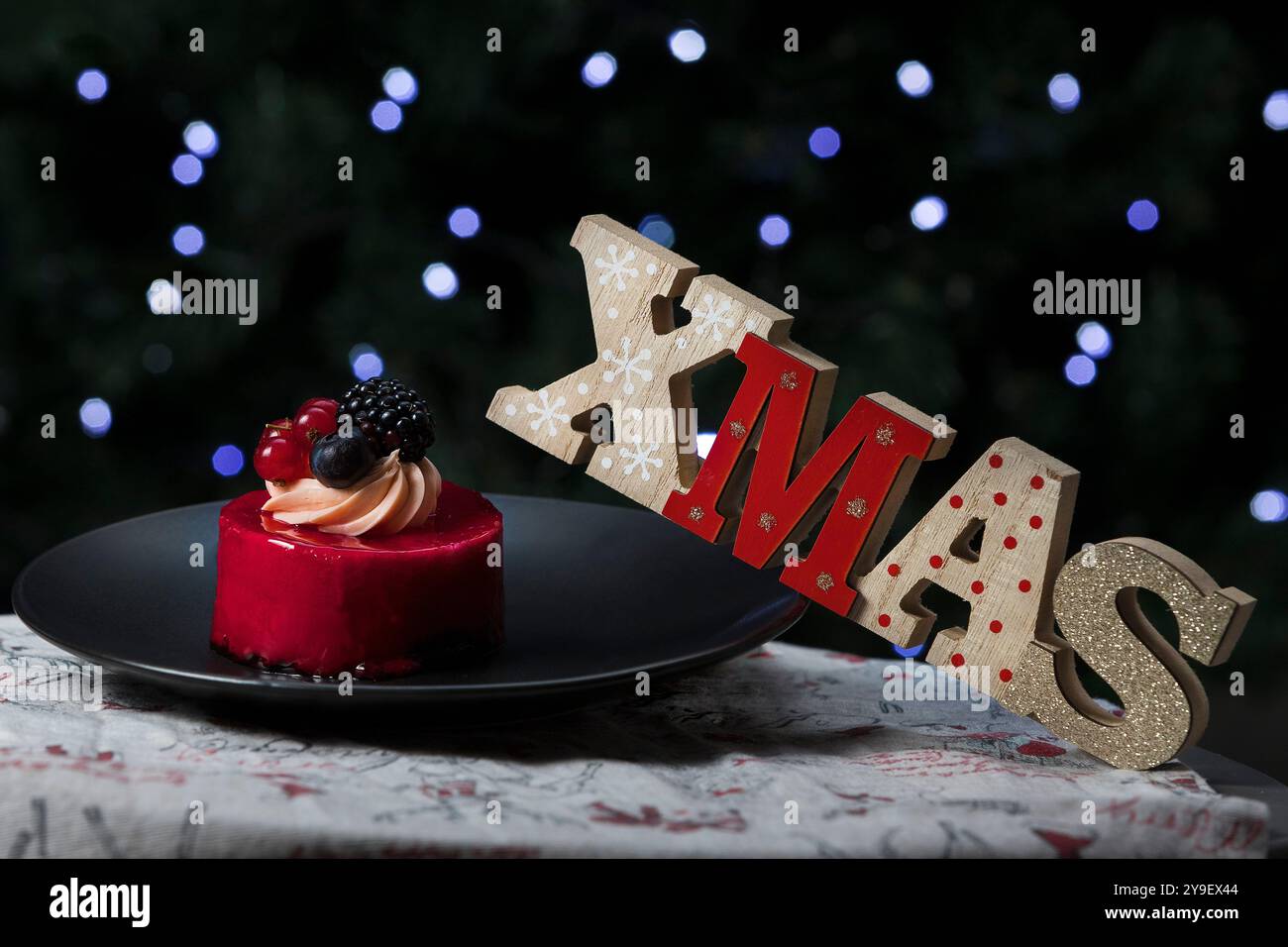 Wunderschöne Torte auf einem Teller neben Weihnachtsdekoration. Weihnachten Hintergrund. Bokeh weihnachten Stockfoto