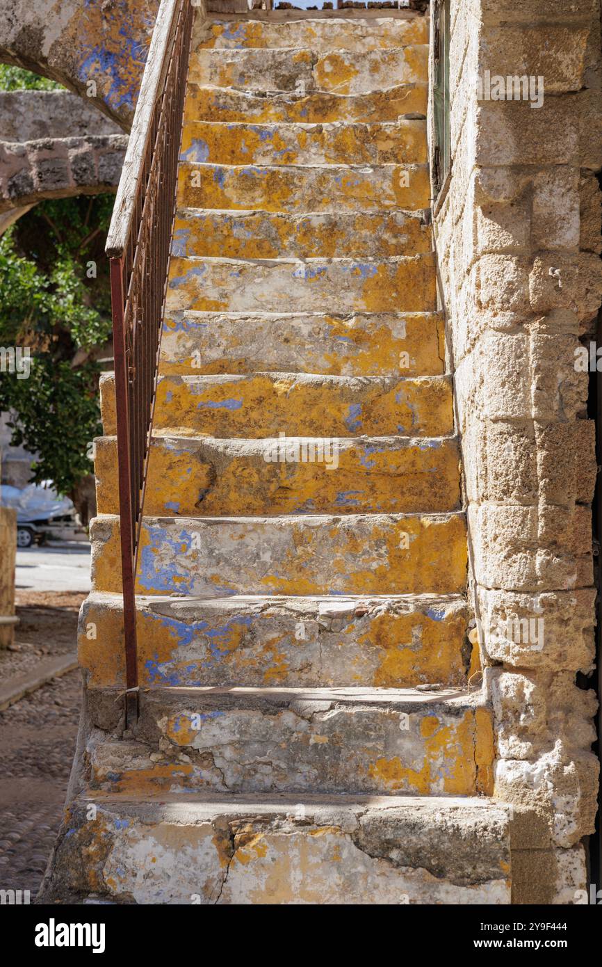 Malerische Treppen, Steintreppen zum Haus in der Altstadt von Rhodos, Griechenland, in Pastellgelb gestrichen. Stockfoto
