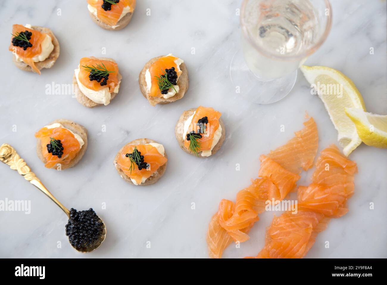 Zarte Räucherlachs-Blinis mit einem Hauch von schwarzem Kaviar und frischem Dill, perfekt für eine elegante Zusammenkunft oder eine Gourmet-Feier. Stockfoto