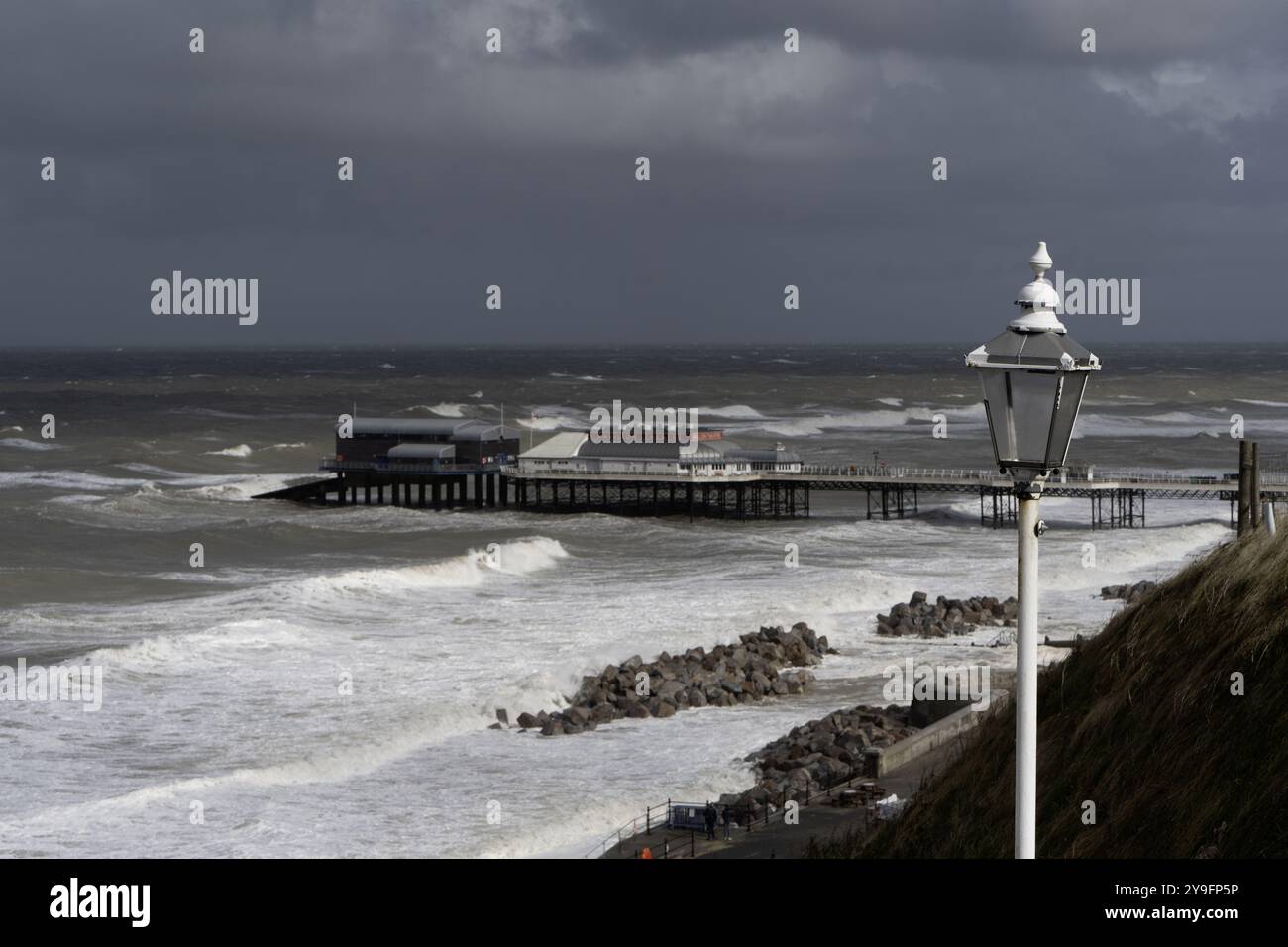 Cromer Pier and Theatre, North Norfolk, Norfolk, England, Großbritannien - Blick auf den Pier mit rauem, dramatischem Meer. Stockfoto