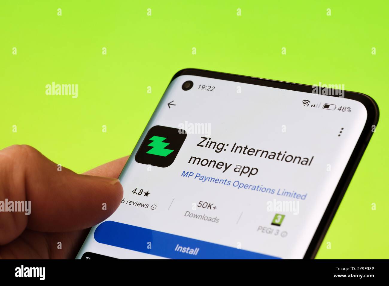 Die Zing International Money App wird auf einem Smartphone-Bildschirm mit über 50 Downloads und einer 4,8-Sterne-Bewertung im Google Play Store angezeigt. Stafford, United Kin Stockfoto