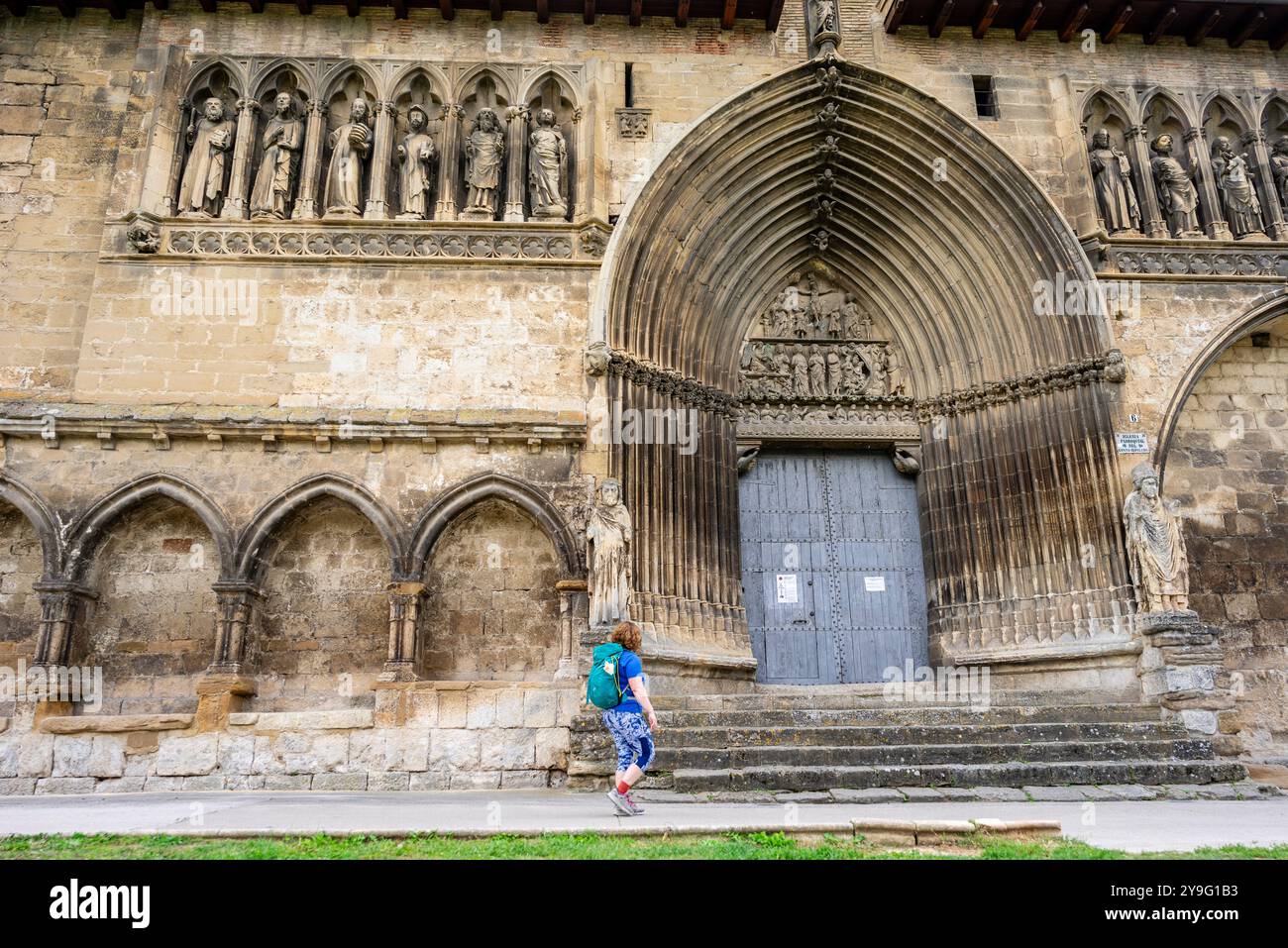 Pilger nach Santiago vor dem gotischen Eingang der Grabeskirche, Estella, Foral Community Navarra, Spanien. Stockfoto