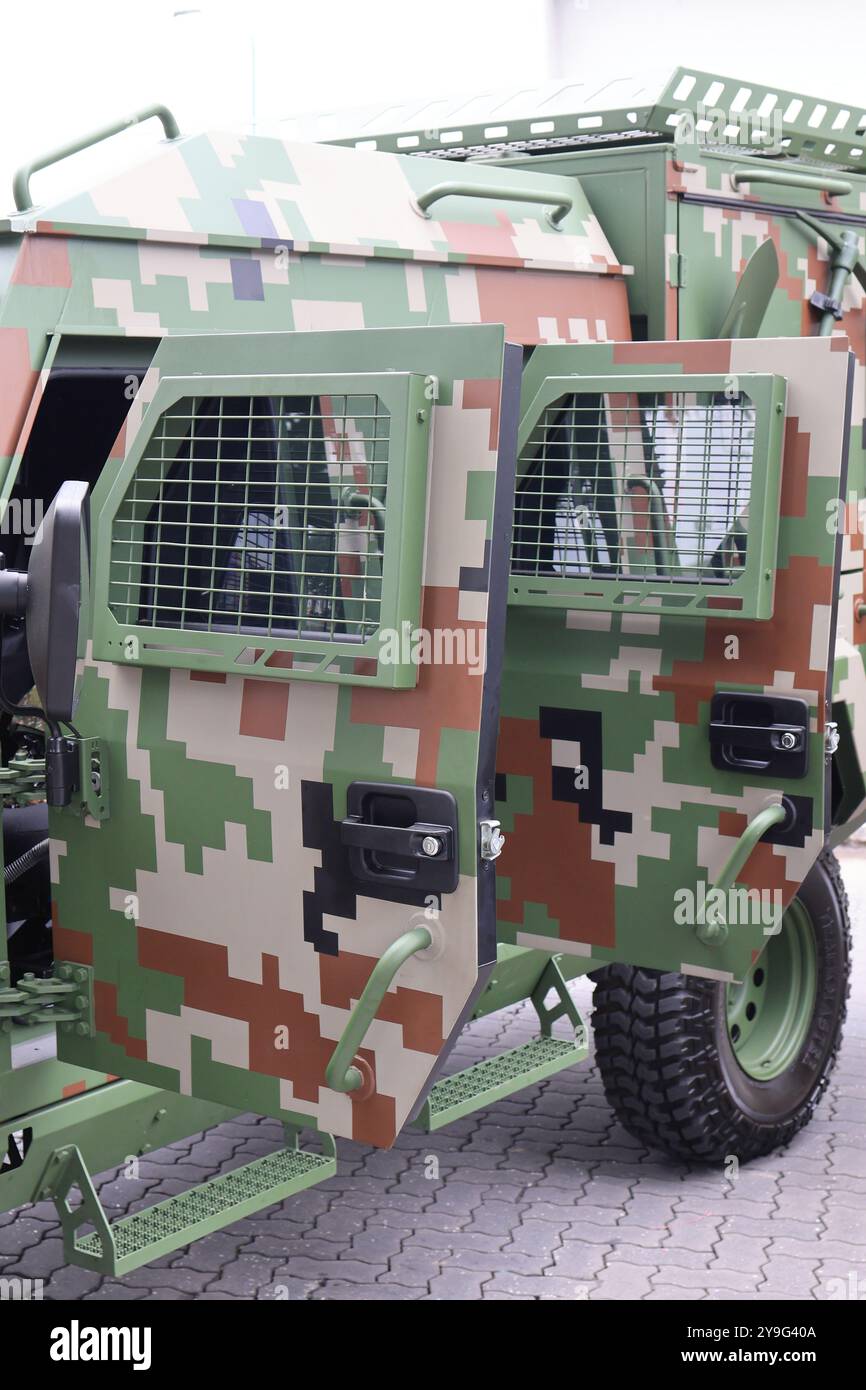 Detaillierte Nahaufnahme eines modernen Militärfahrzeugs mit pixeliger Tarnung und Schutzgittern. Stockfoto