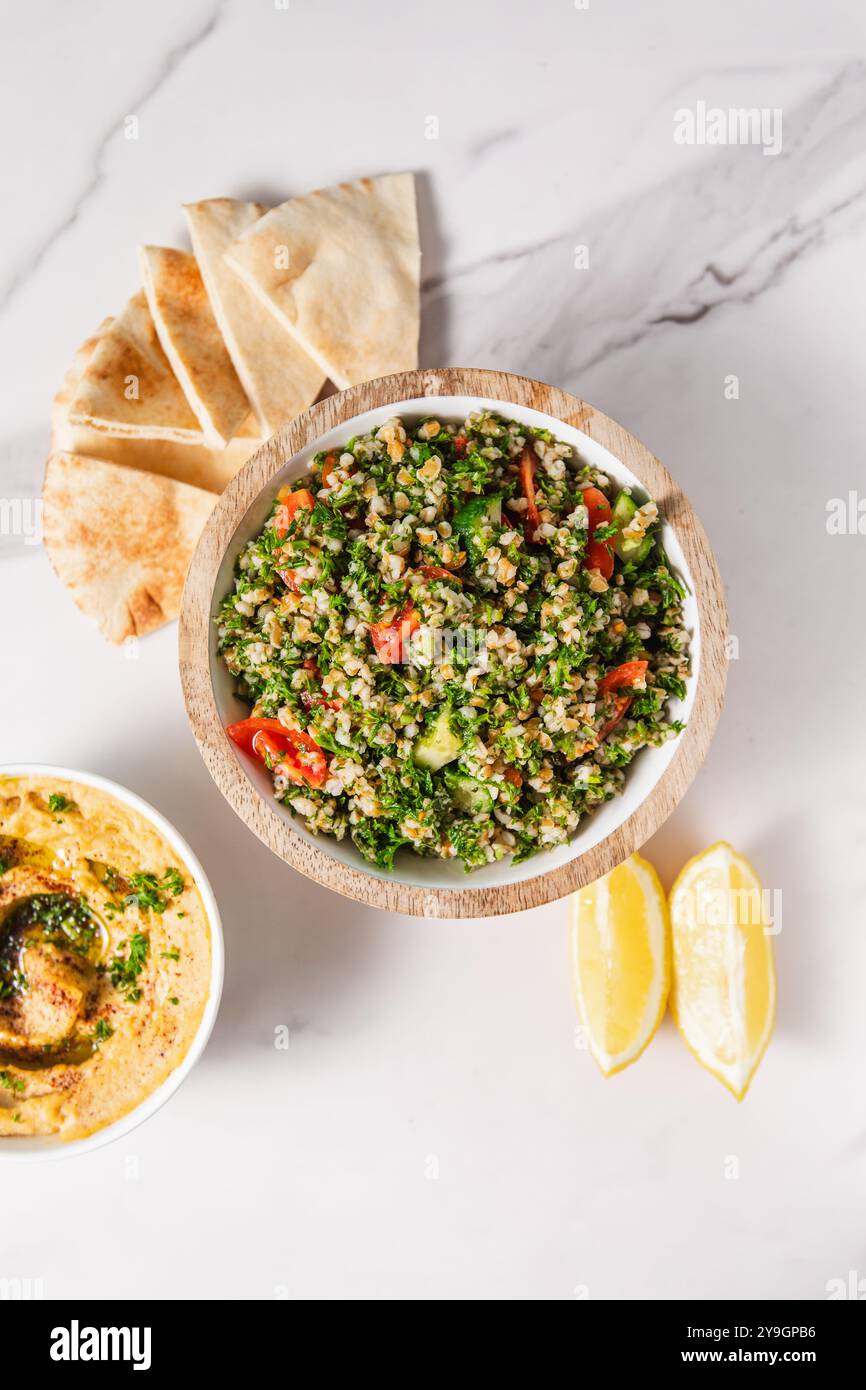 Tabbouleh-Salat mit Tomaten, Pita-Brot, Zitronenscheiben und Hummus Stockfoto