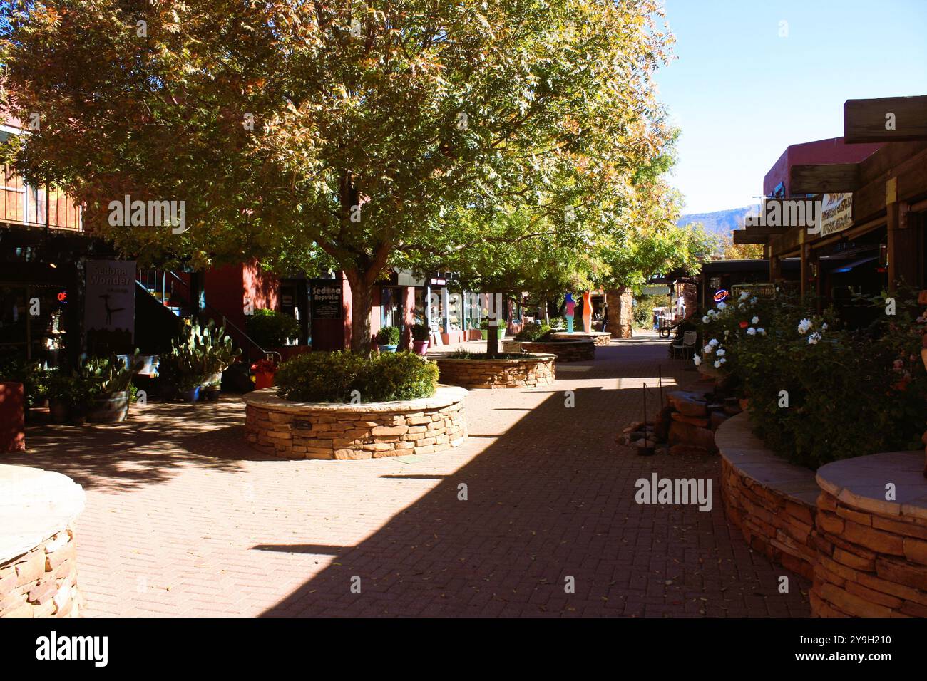 Dieses Foto zeigt die Innenstadt von Sedona, Arizona, eingerahmt von lebendiger öffentlicher Kunst und den majestätischen roten Felsformationen Stockfoto