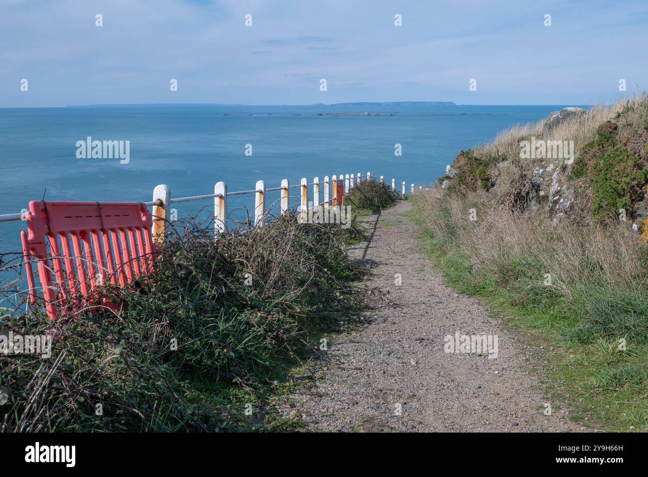 Ein malerischer Küstenpfad am Sorel Point mit einem verwitterten Zaun überblickt das Meer, lädt zum Erkunden ein und bietet atemberaubende Ausblicke. Stockfoto