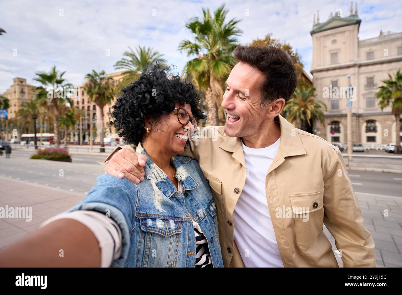Glückliches, reifes, multiethnisches Touristenpaar, das Selfie macht und sich gegenseitig ansieht Stockfoto