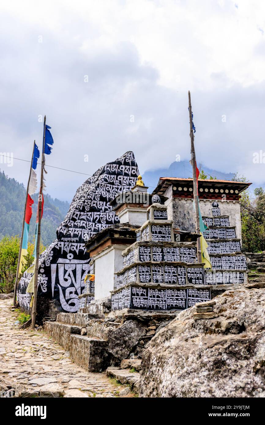 Mani-Steine mit heiligen Symbolen in den nepalesischen Himalaya-Bergen auf einem Wanderweg. Religiöser heiliger Ort in Nepal Stockfoto