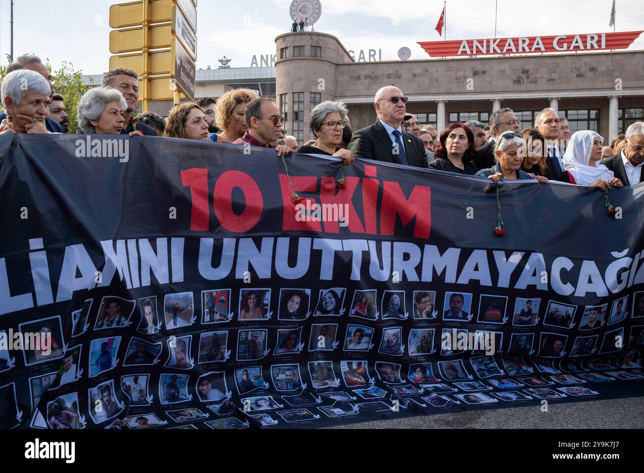 Die Demonstranten beobachten einen Moment des Schweigens am Ort der Explosion. Am 10. Oktober 2015 verübte der IS einen Selbstmordanschlag auf Tausende von Menschen, die zum Bahnhof Ankara gekommen waren. Als Folge des Attentats kamen 104 Menschen ums Leben, und die Toten wurden von ihren Angehörigen, Politikern und Berufsverbänden am neunten Jahrestag des Massakers geehrt. Hunderte von Menschen nahmen an der Gedenkfeier des Bahnhofsmassakers Teil, bekannt als der blutigste Terroranschlag in der türkischen Geschichte. Ein Banner mit Fotos von denen, die es sehen Stockfoto