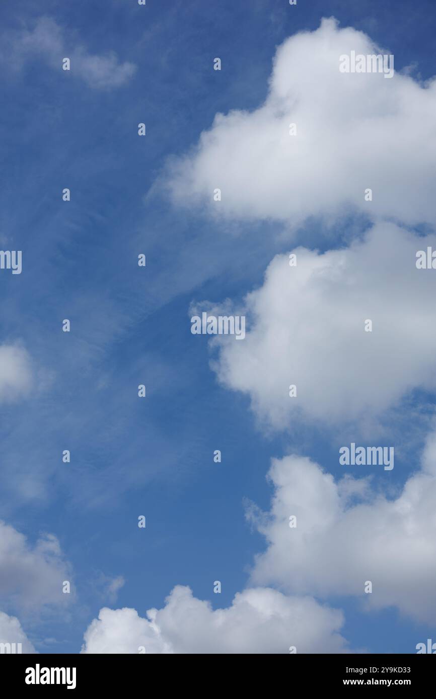 Drei Kumulus-Wolken stapeln sich in einer vertikalen Linie und erzeugen ein Bild von drei flauschigen Punkten am Himmel. Stockfoto
