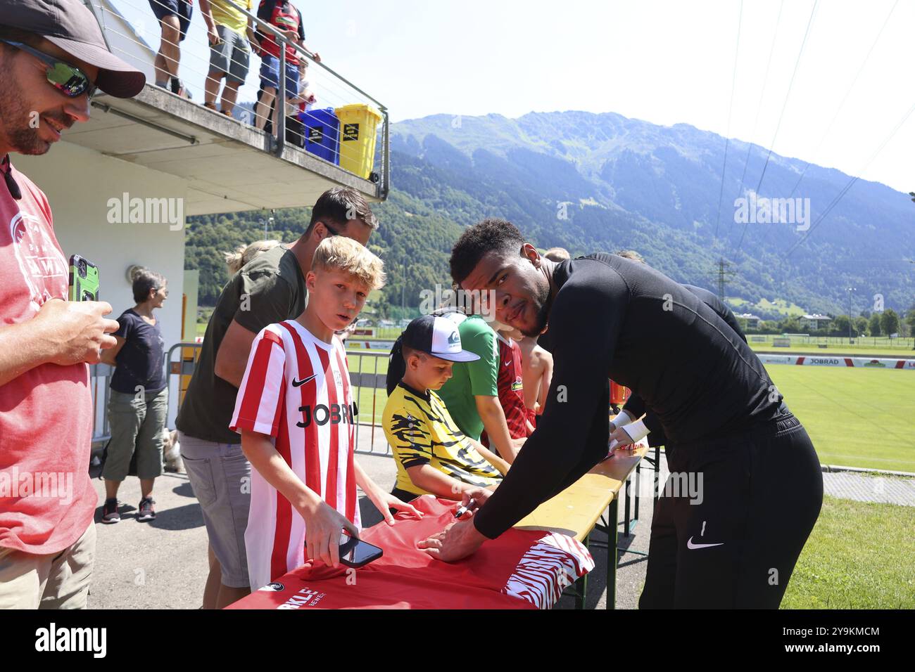 Torhüter Noah Atubolu (SC Freiburg) signiert Autogramme für die jungen Fußballer nach dem Training im Trainingslager SC Freiburg Schruns 2024 DFL REGU Stockfoto