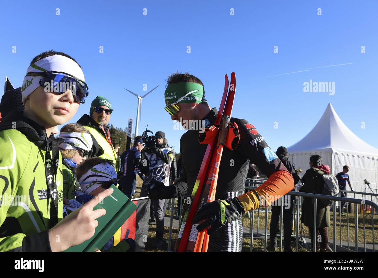 Fabian Riessle (SZ Breitnau/Deutschland) gibt den jungen Fans nach der Überquerung der Ziellinie bei der FIS Nordic Combined World Cup ein Autogramm Stockfoto