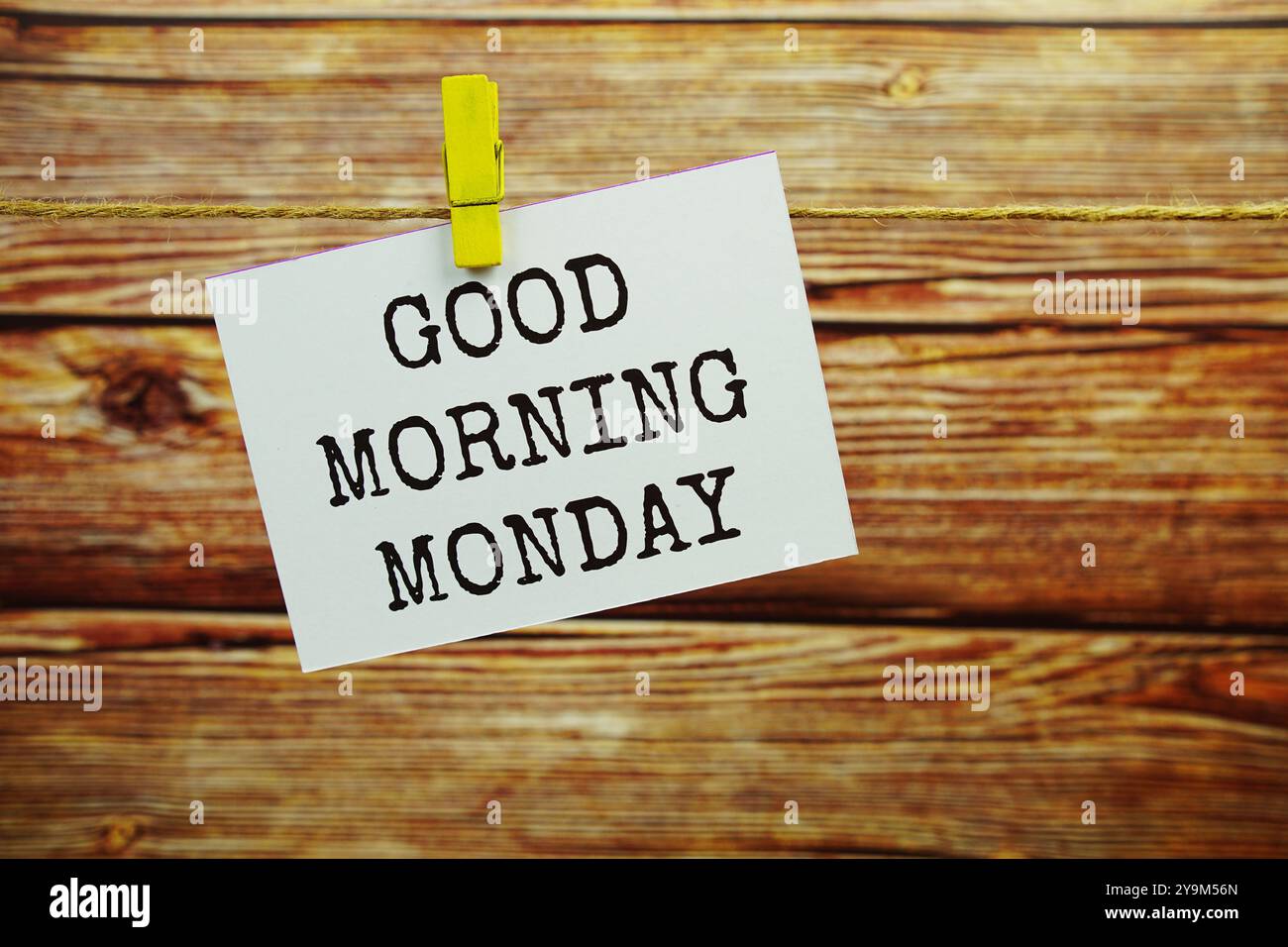 Guten Morgen Montag Text auf Papierkarte, die an der Wand hängt, mit Kleiderschachteln Stockfoto