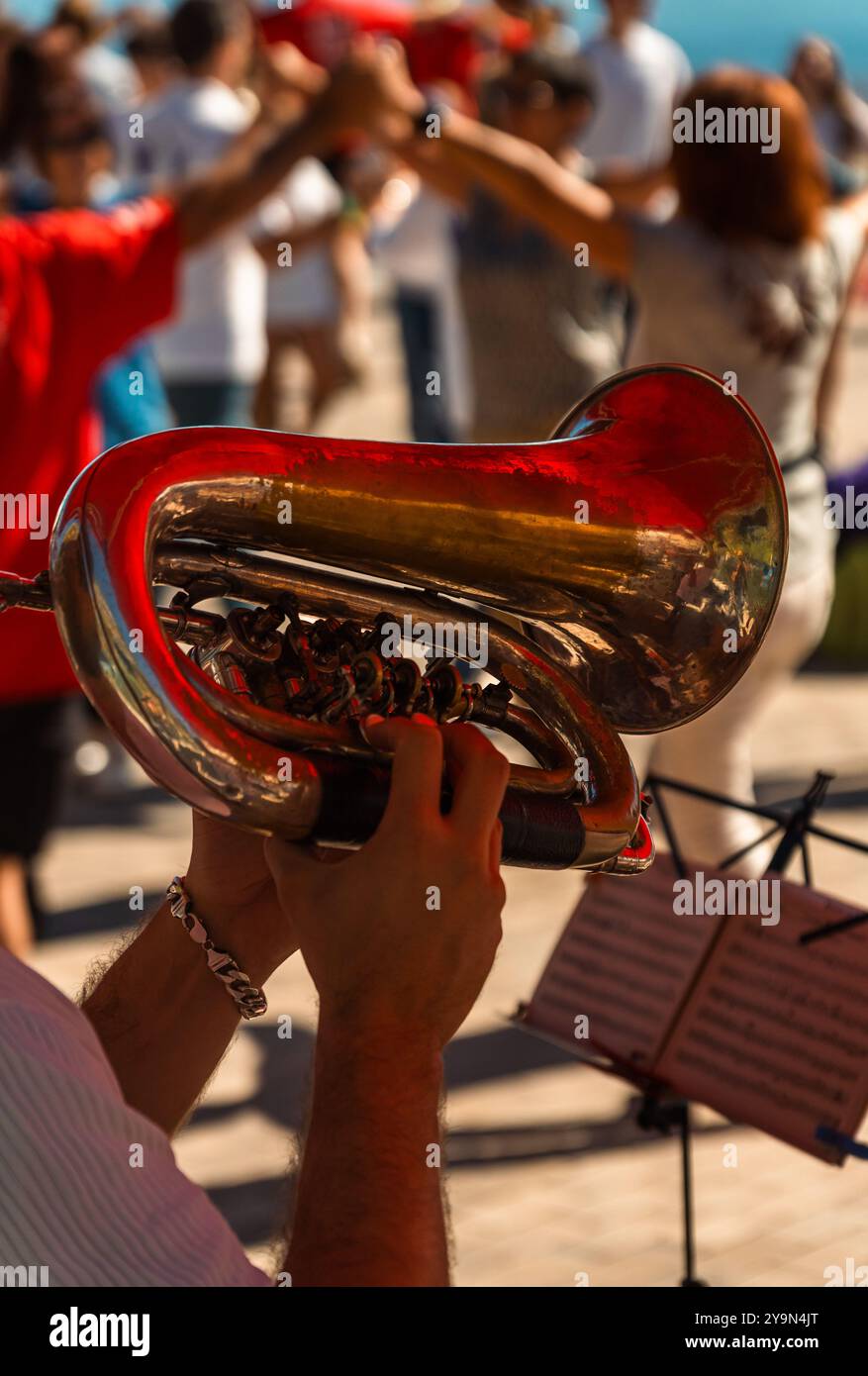 Trompeter spielen ein Flugelhorn und spielen katalanische Volksmusik bei einem Outdoor-Event am Meer, bei dem die Menschen in Barcelona die katalanische Sardana tanzen. Stockfoto