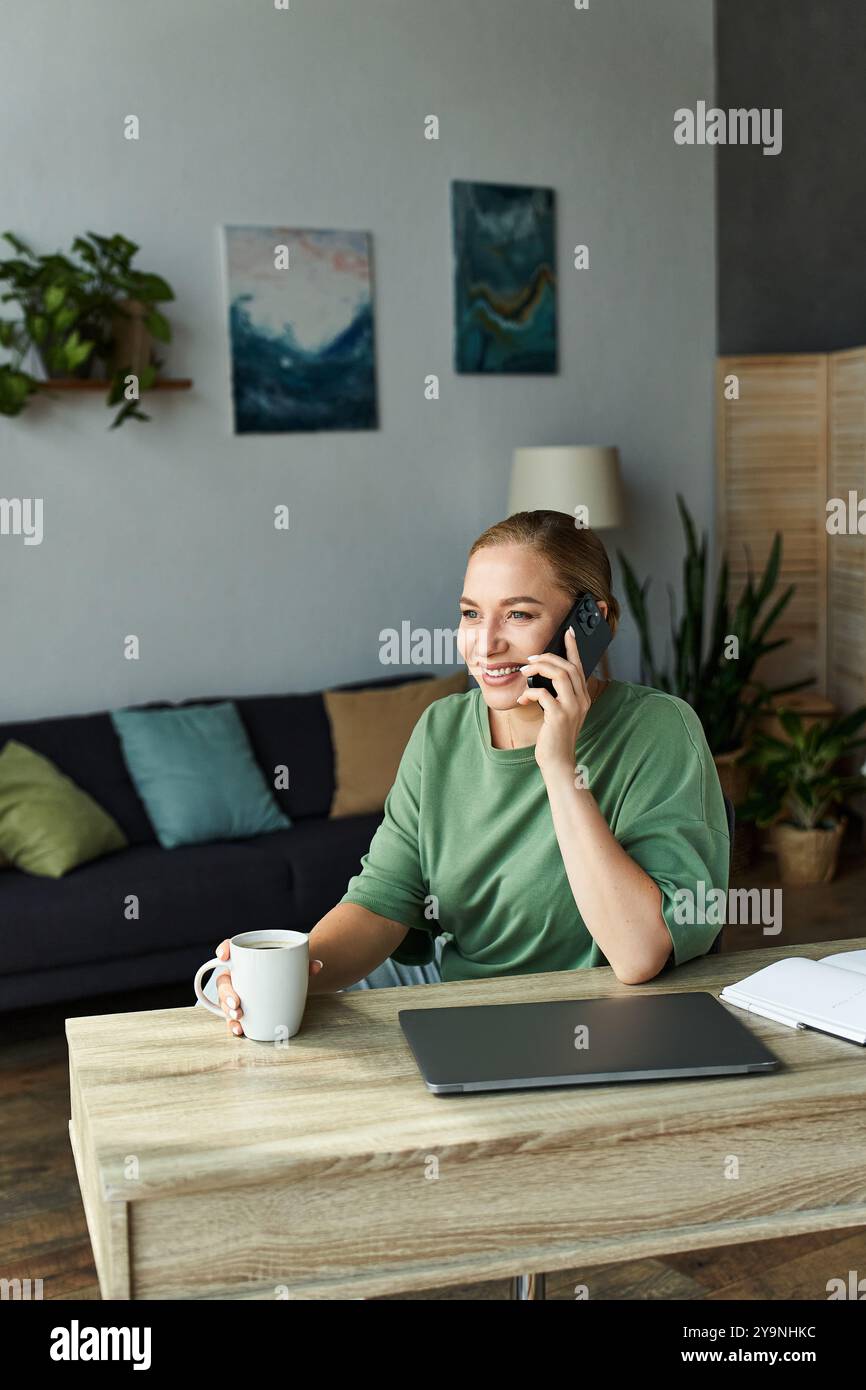 Eine fröhliche junge Frau in Übergröße plaudert am Telefon, während sie Kaffee in ihrem Wohnzimmer schlürft. Stockfoto
