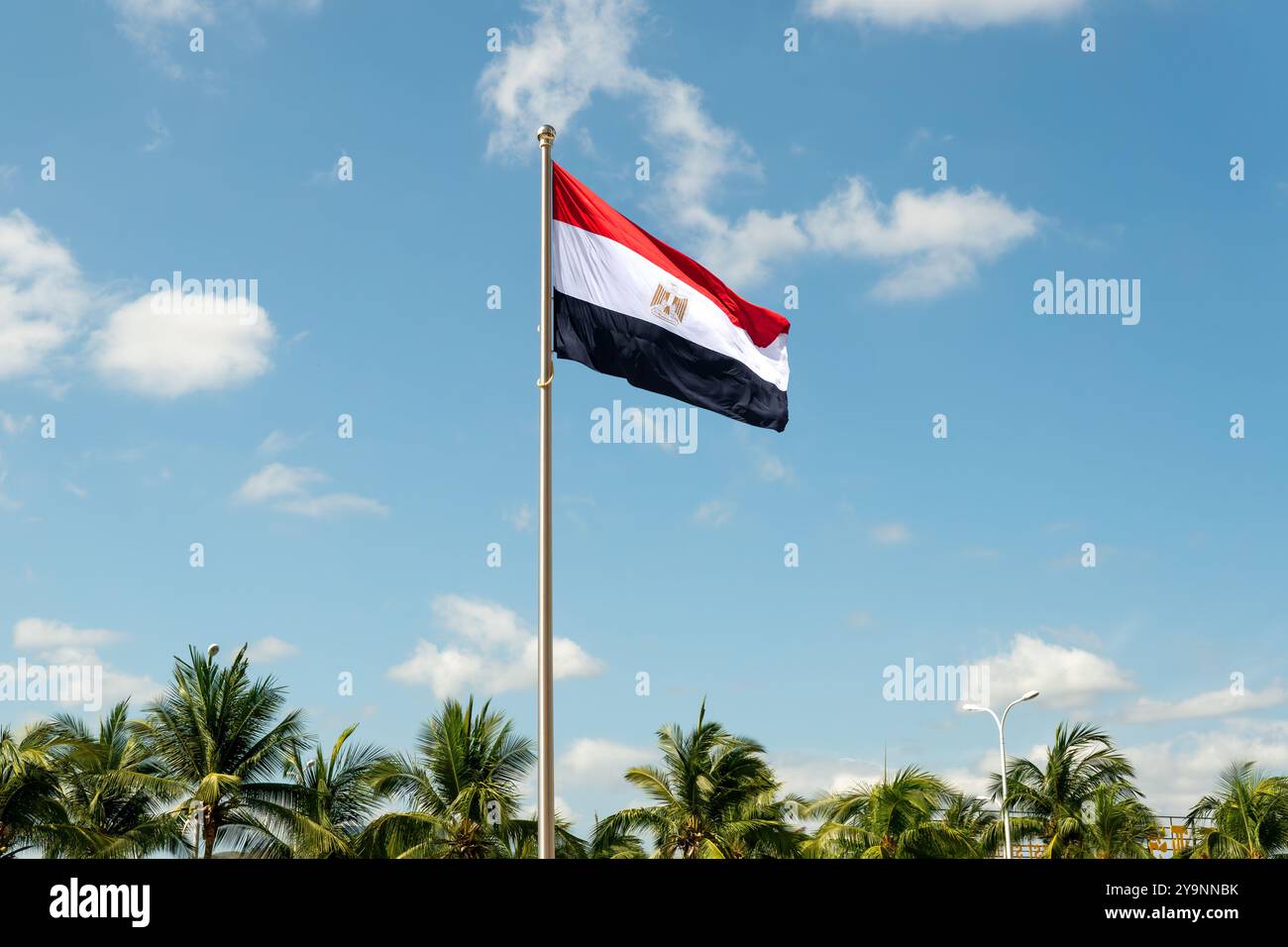 Flagge am Pfosten gegen blauen Himmel. Große Flagge Ägyptens, die im Wind winkt Stockfoto